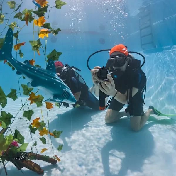 Alumno haciendo el curso de fotografía en pileta y fotografiando objetos
