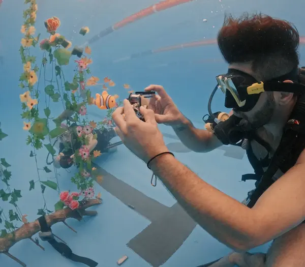 Alumno haciendo el curso de fotografía en pileta y fotografiando objetos