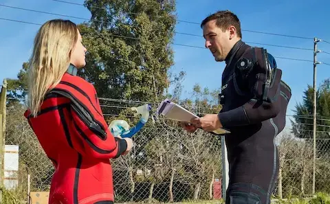 Alumna repasando junto a su instructor la teoría antes de certificar en aguas abiertas en El Buda